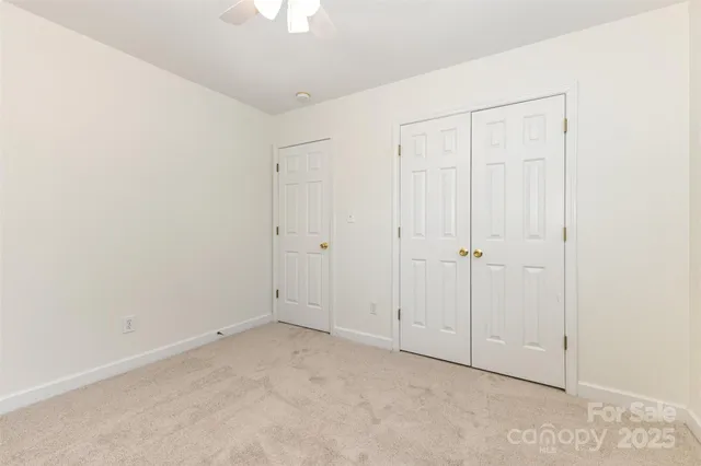 an empty room with a chandelier fan