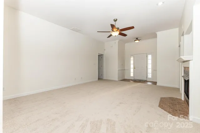 an empty room with a ceiling fan and a window