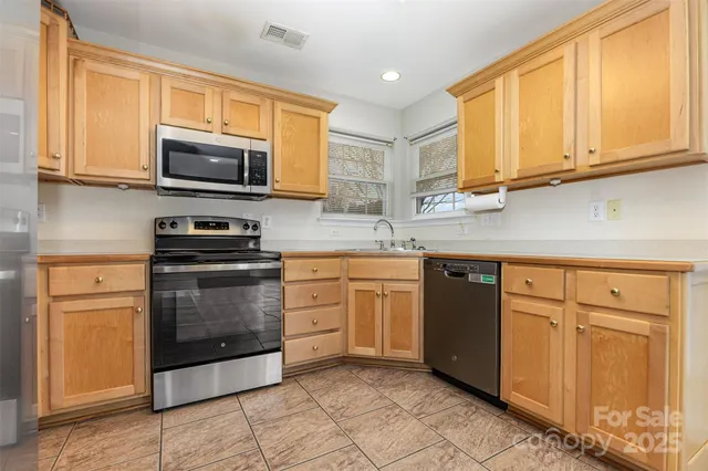 a kitchen with stainless steel appliances granite countertop a stove microwave and sink