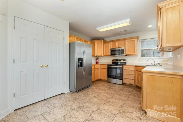 a kitchen with granite countertop a refrigerator sink stove and cabinets