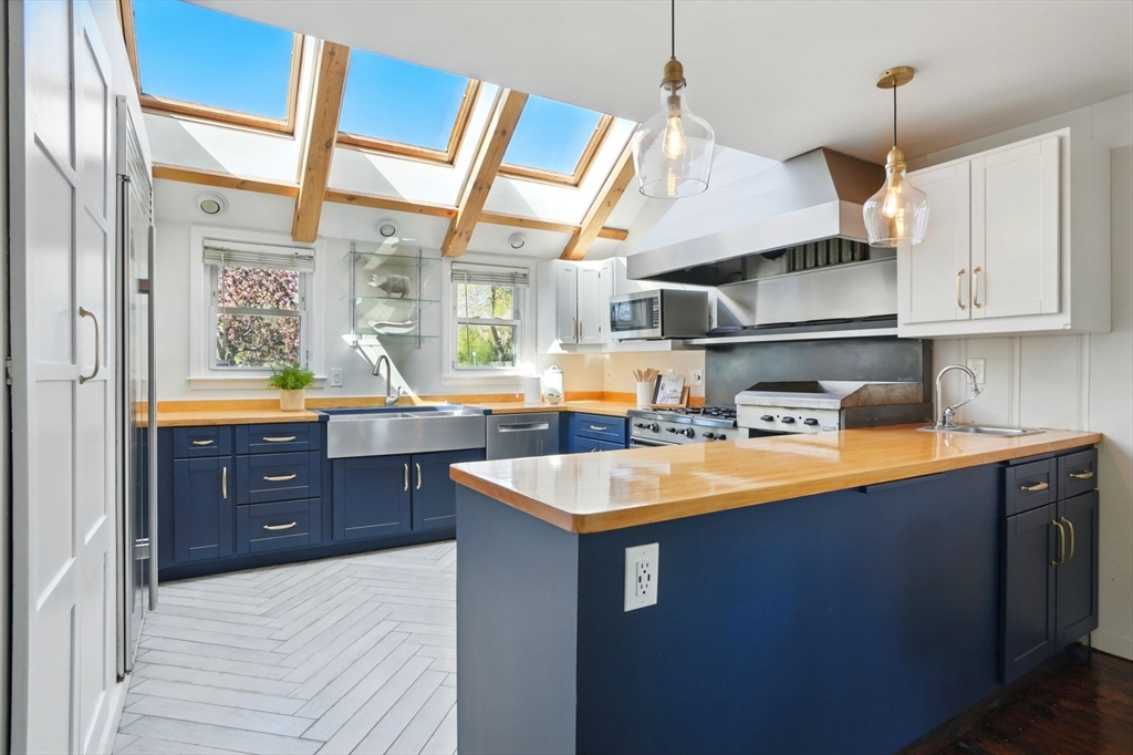 181 Grove Street Cambridge, MA 02138 - Photo 6 of 22 a kitchen with stainless steel appliances granite countertop a sink a stove and a wooden floors