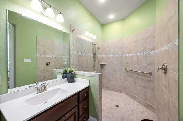 a bathroom with a bathtub shower sink vanity and a mirror