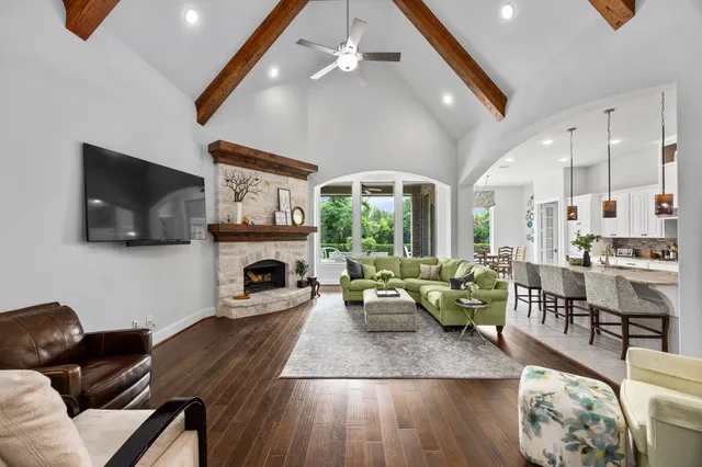 a living room with stainless steel appliances kitchen island granite countertop a couch and white cabinets
