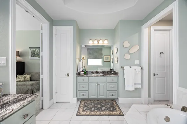a spacious bathroom with a granite countertop sink mirror vanity and bathtub