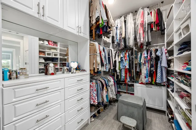 a view of walk in closet with clothes and shoes