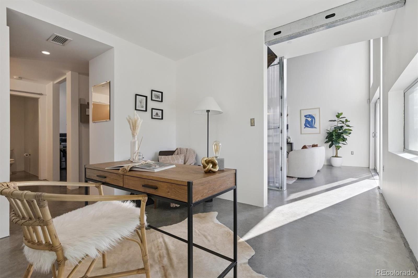 3457 Ringsby Court, Unit 320 Denver, CO 80216 - Photo 25 of 41 a view of a room with furniture and wooden floor
