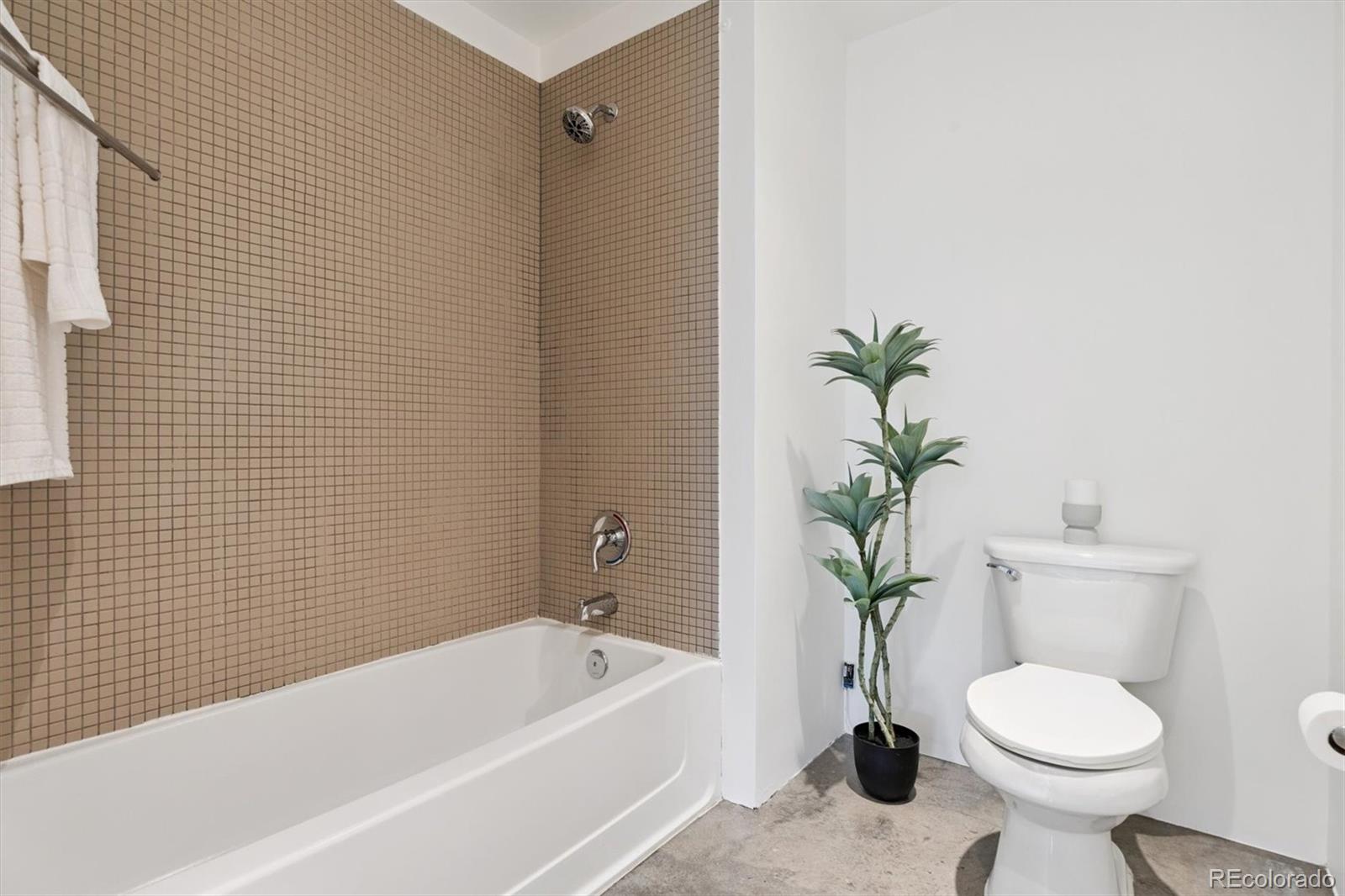 3457 Ringsby Court, Unit 320 Denver, CO 80216 - Photo 26 of 41 a bathroom with a sink toilet and a bathtub