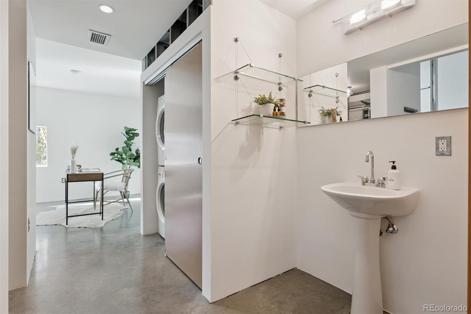 3457 Ringsby Court, Unit 320 Denver, CO 80216 - Photo 27 of 41 a bathroom with a sink and a mirror