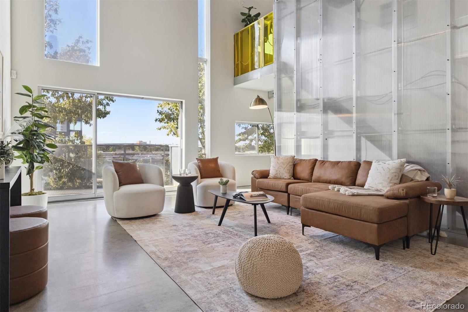 3457 Ringsby Court, Unit 320 Denver, CO 80216 - Photo 3 of 41 a living room with furniture a rug and a fireplace