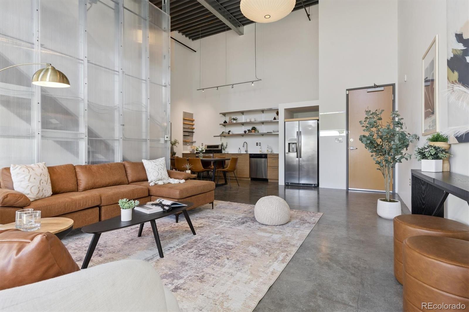 3457 Ringsby Court, Unit 320 Denver, CO 80216 - Photo 5 of 41 a living room with furniture and a chandelier