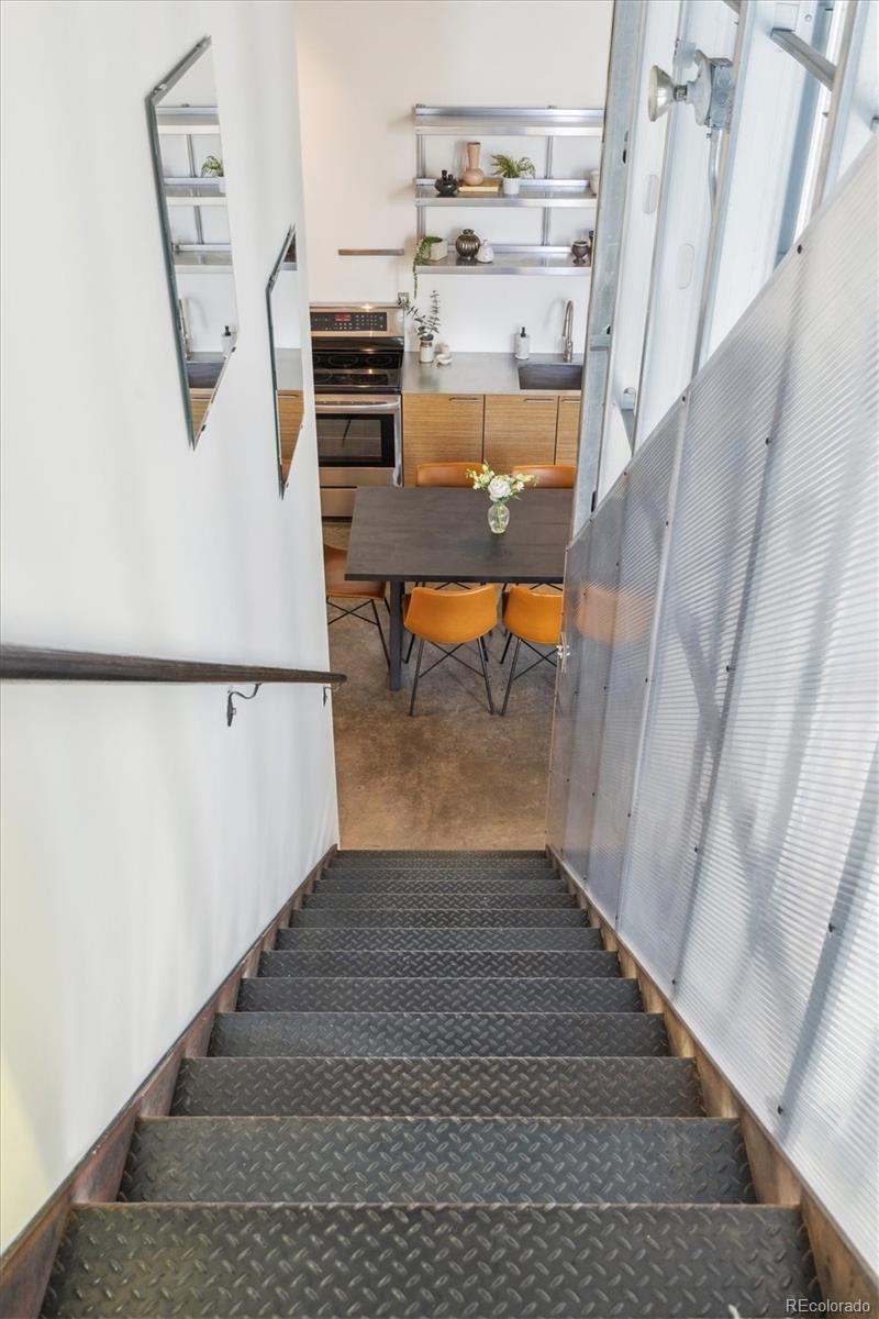 3457 Ringsby Court, Unit 320 Denver, CO 80216 - Photo 10 of 41 a view of a hallway to a livingroom with furniture