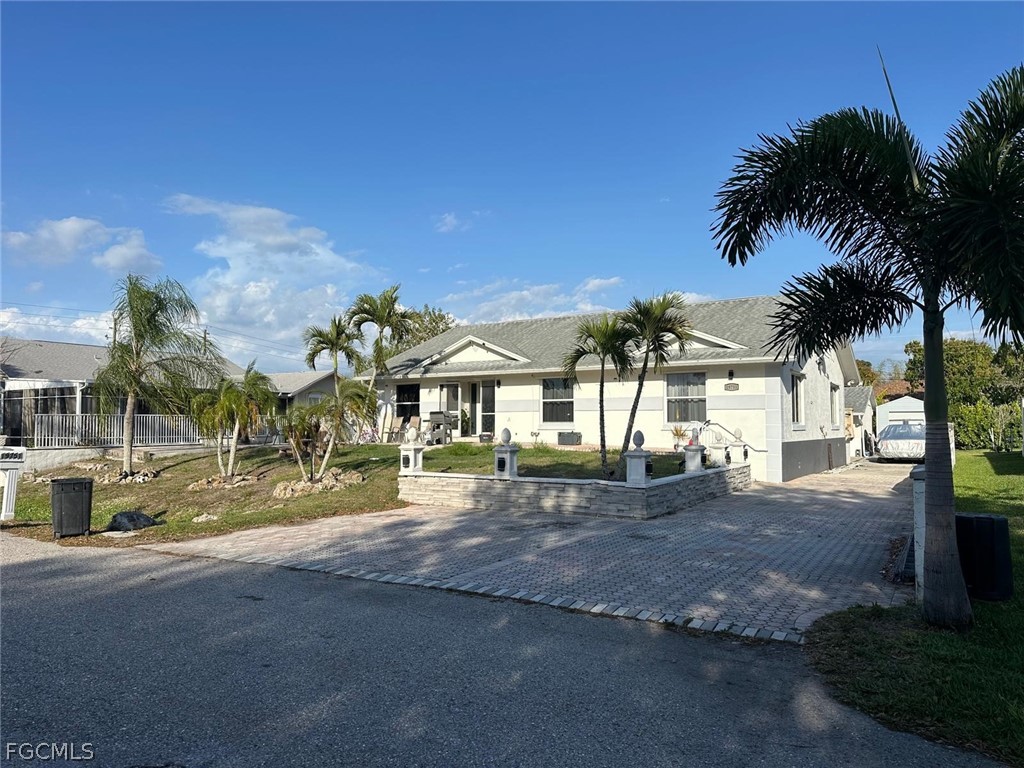 a view of a house with a yard and palm trees