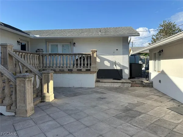 a view of a house with a patio and a yard