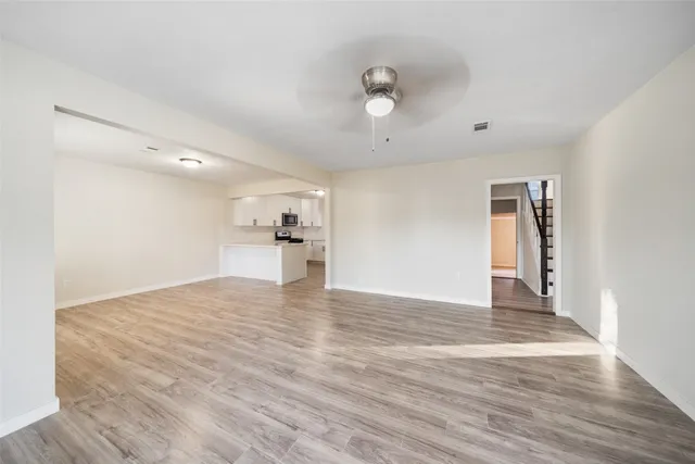 a view of empty room with wooden floor