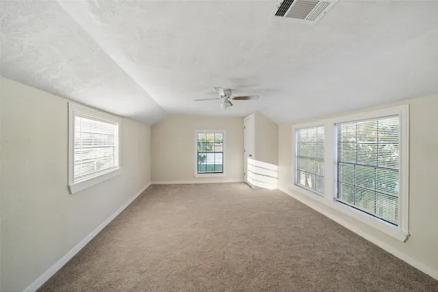 a view of a big room with windows and chandelier fan