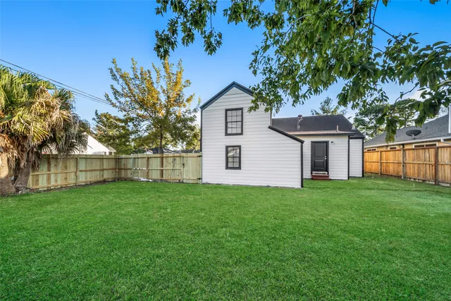 a view of a backyard with plants and wooden fence