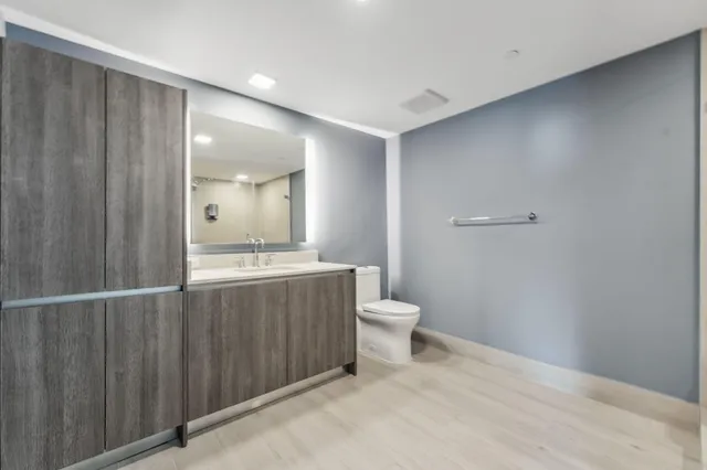 a bathroom with a toilet a sink and mirror