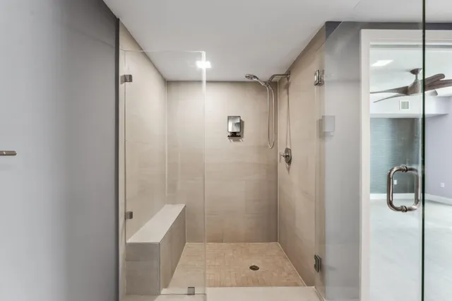 a bathroom with a shower and a glass door