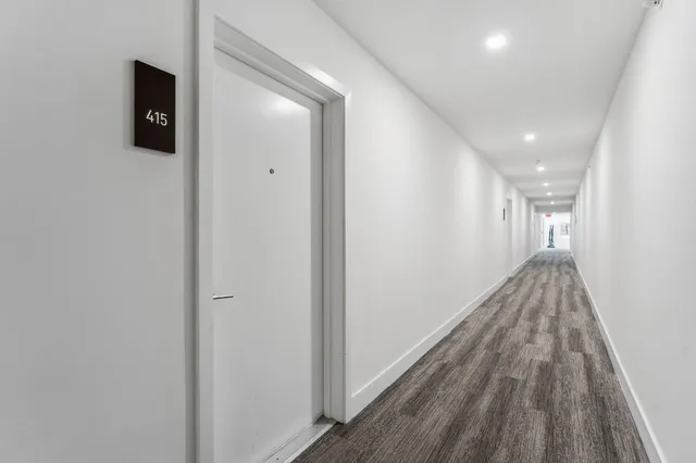 a view of hallway with wooden floor