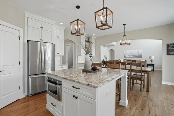 a kitchen with stainless steel appliances granite countertop a stove refrigerator and wooden floor