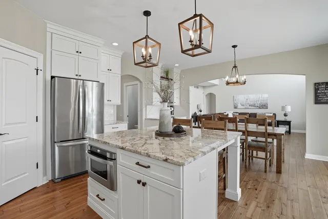 a kitchen with stainless steel appliances granite countertop a stove refrigerator and wooden floor