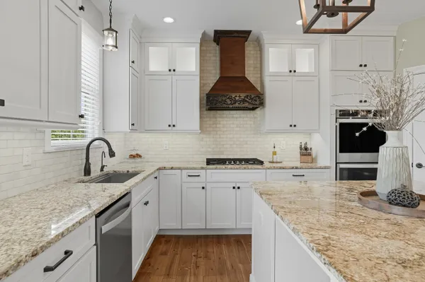 a kitchen with stainless steel appliances granite countertop a sink stove and cabinets