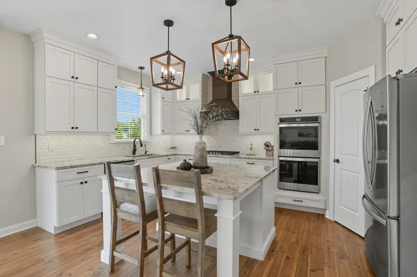 a kitchen with stainless steel appliances granite countertop a stove refrigerator and microwave