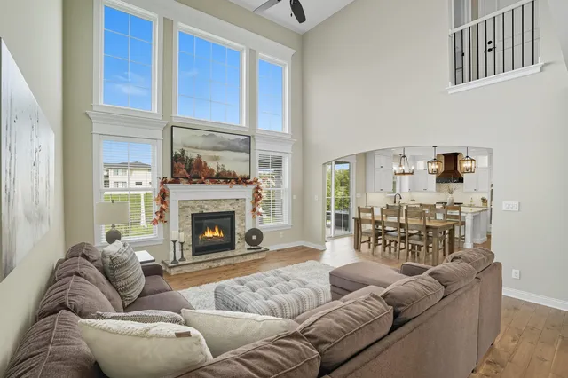 a living room with furniture a fireplace and a large window