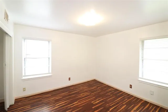a view of a room with wooden floor and windows in it