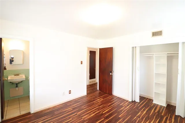 a view of a room with wooden floor and a bathroom