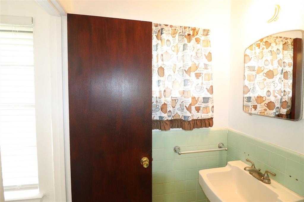 9107 Rustown Drive Dallas, TX 75228 - Photo 14 of 30 a bathroom with a sink and mirror with toilet