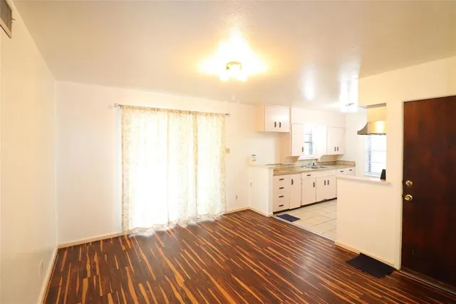 a kitchen with a refrigerator and white cabinets