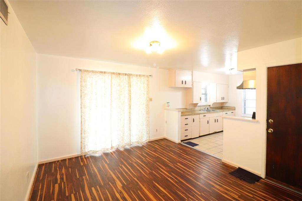 9107 Rustown Drive Dallas, TX 75228 - Photo 4 of 30 a kitchen with a refrigerator and white cabinets