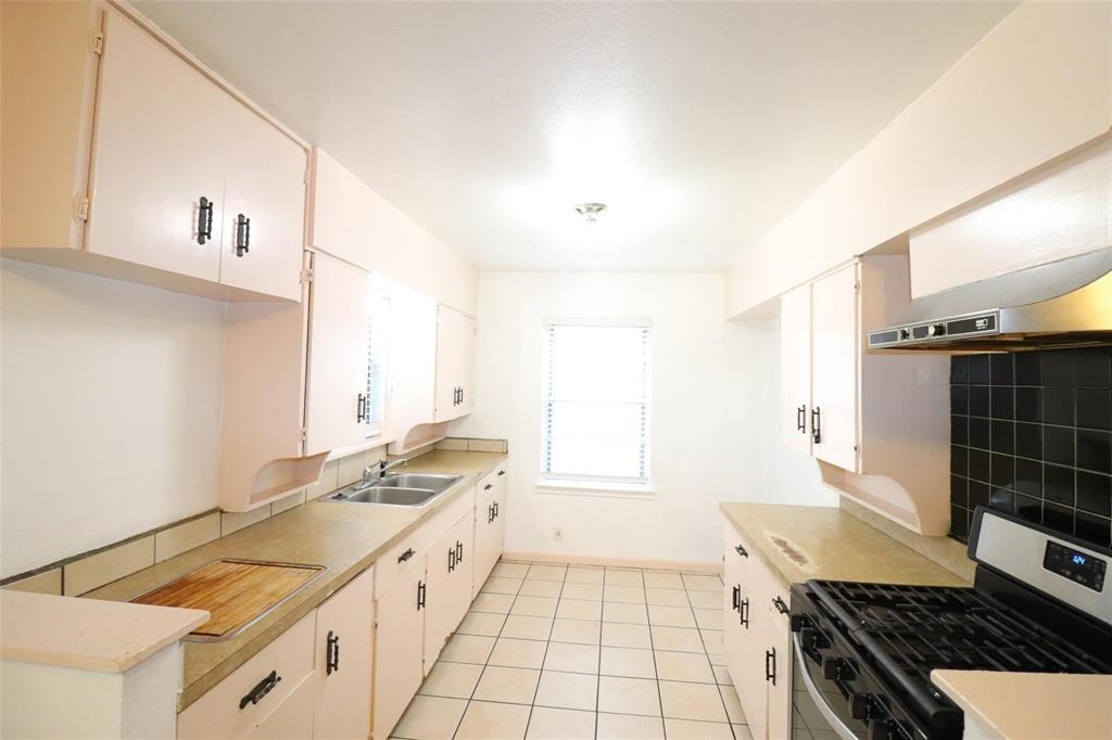 9107 Rustown Drive Dallas, TX 75228 - Photo 6 of 30 a kitchen with granite countertop a sink and a stove top oven