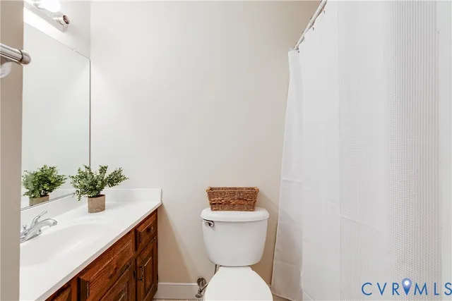 a bathroom with a granite countertop toilet and a sink