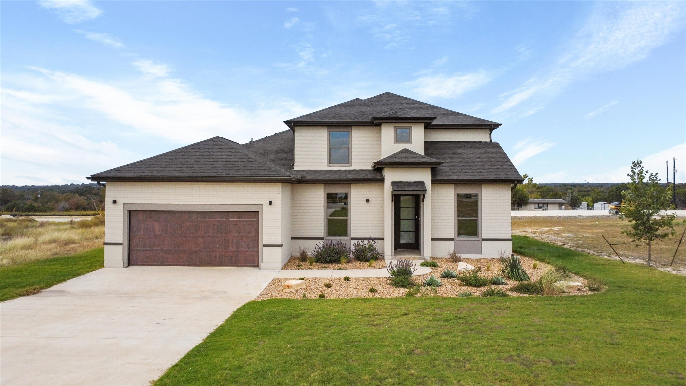 a front view of a house with a garden and yard