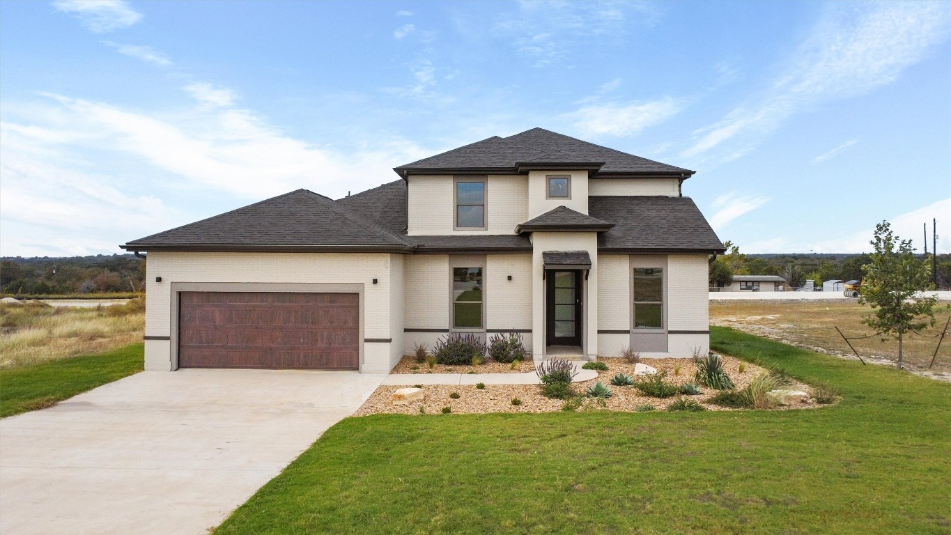 a front view of a house with a garden and yard