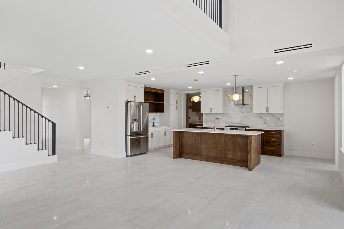 109 Fall Drive Georgetown, TX 78633 - Photo 12 of 40 a large kitchen with stainless steel appliances kitchen island granite countertop a large counter top and oven