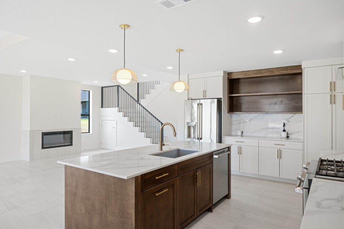 109 Fall Drive Georgetown, TX 78633 - Photo 16 of 40 a kitchen with stainless steel appliances granite countertop a sink a stove and a wooden floors