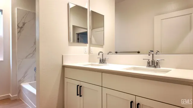 a bathroom with a double vanity sink and a mirror