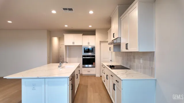 a kitchen with stainless steel appliances kitchen island granite countertop a stove and a refrigerator