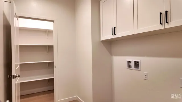 a view of kitchen with white cabinets and a window
