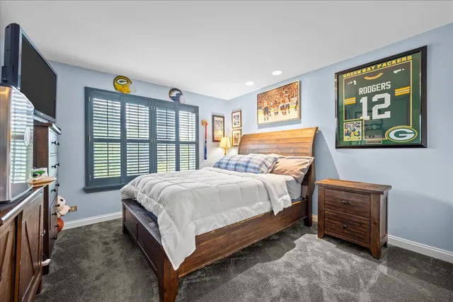 a bed sitting in a spacious bedroom next to a window