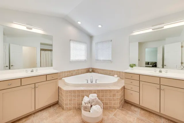 a spacious bathroom with a tub sink and mirror
