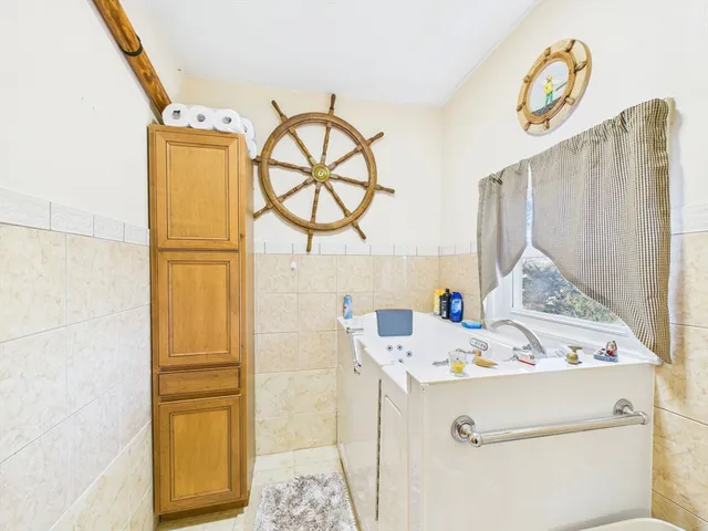 a bathroom with a tub a sink and a mirror