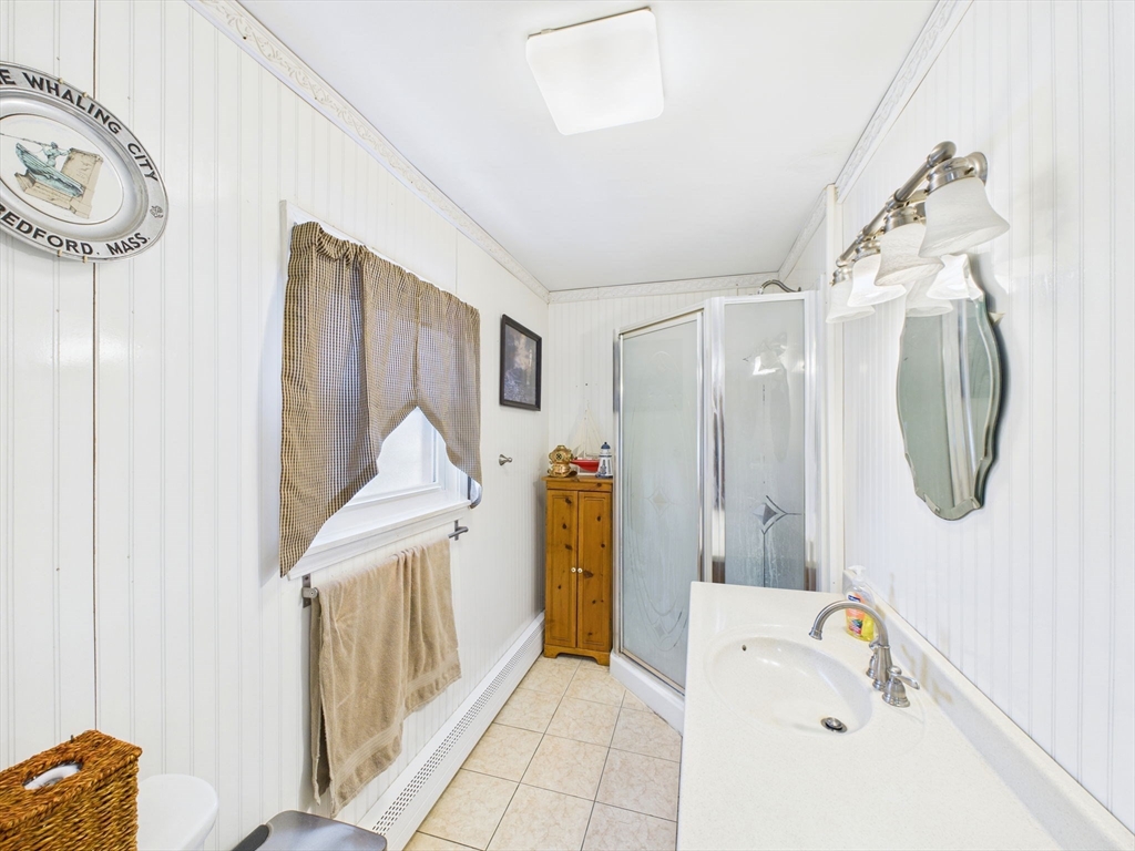 371 Reed Street New Bedford, MA 02740 - Photo 15 of 42 a bathroom with a tub a sink and a mirror