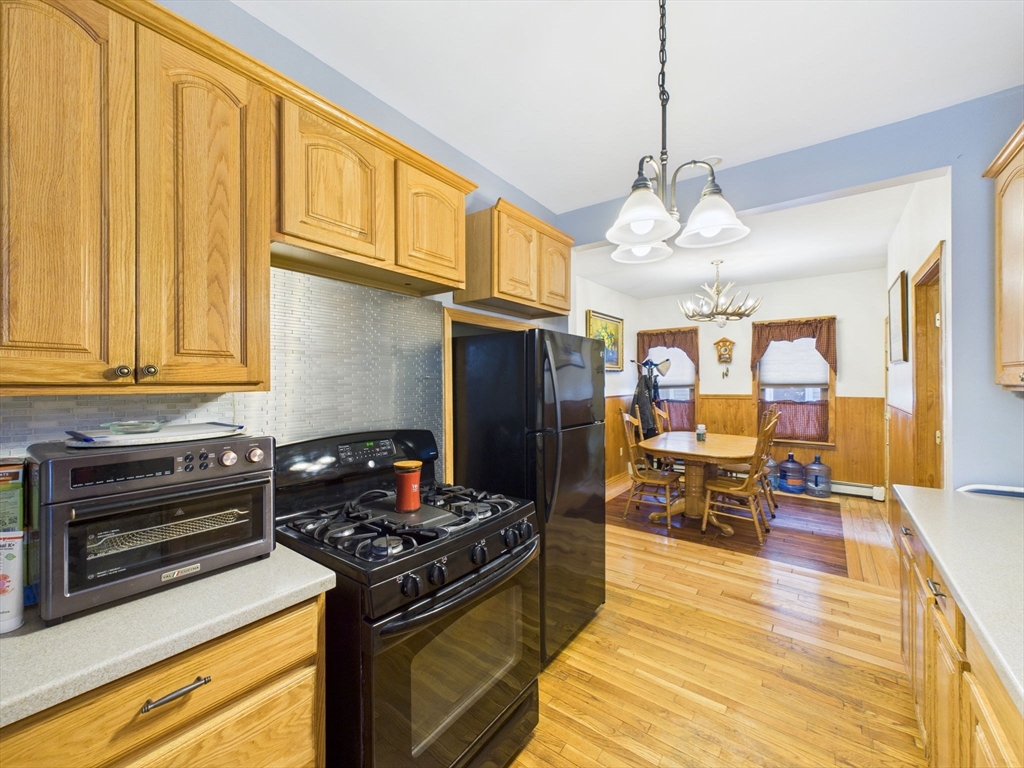 371 Reed Street New Bedford, MA 02740 - Photo 16 of 42 a kitchen with stainless steel appliances granite countertop a stove and a wooden cabinets