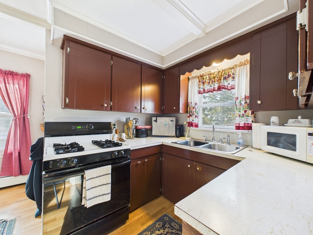 371 Reed Street New Bedford, MA 02740 - Photo 29 of 42 a kitchen with a sink a stove and cabinets