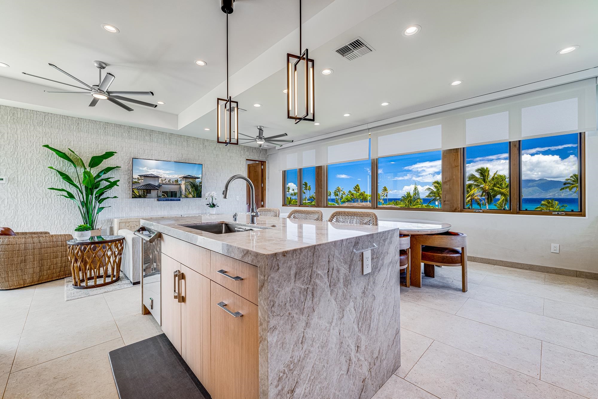 5385 Lower Honoapiilani Road Lahaina, HI 96761 - Photo 20 of 42 a kitchen with stainless steel appliances kitchen island a large counter top a sink a stove a dining table and chairs
