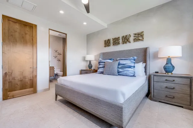 a spacious bedroom with a bed and a lamp